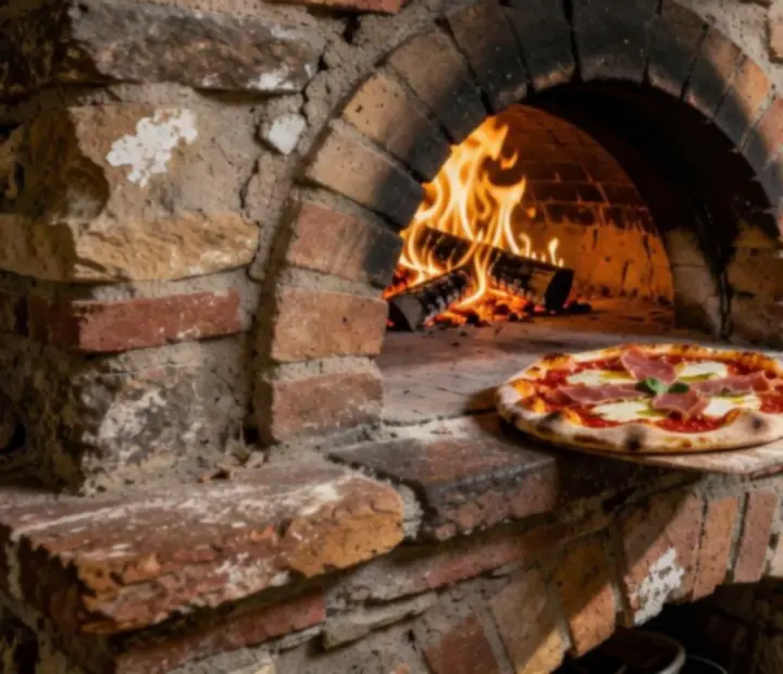 A Kozponthely konyhában izzó fatüzelésű pizzasütő kész pizzahéjjal.